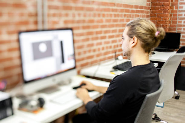 istock Young designer working in the graphic design industry. The young entrepreneur is encoding for virtual reality technology. Vanguardian startup. Millennial. Real life. Real people. 892982646