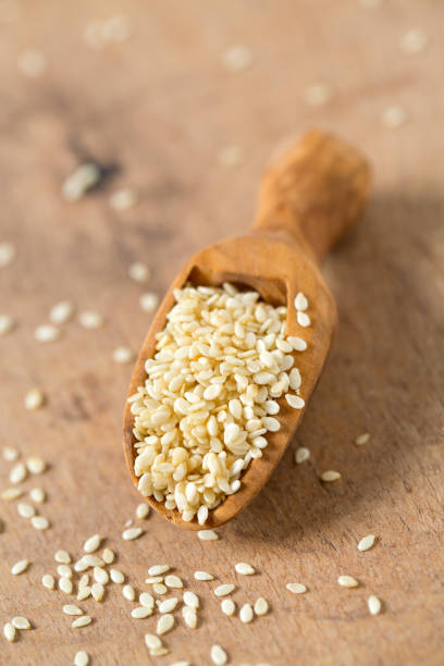sesame seeds in a wooden scoop stock photo