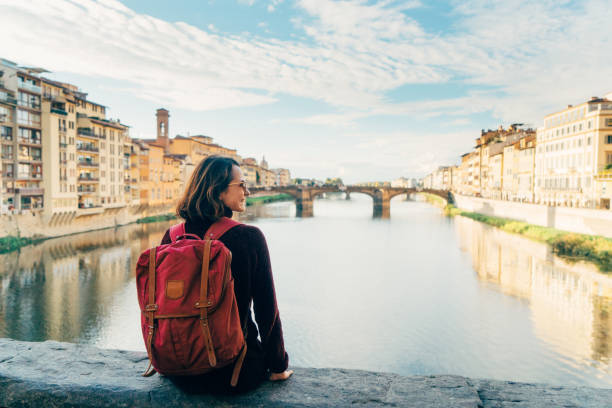 istock Woman sitting on Ponte Veccio and looking at view 892995530