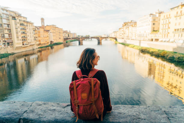 istock Woman sitting on Ponte Veccio and looking at view 892995536