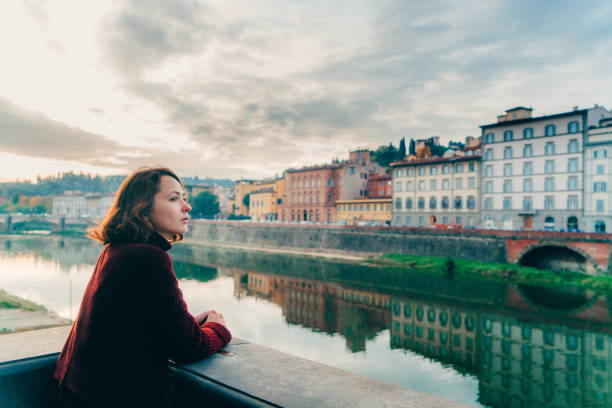 istock Woman looking at the river Arno in Florence 893006174