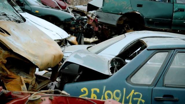 close up shot of the cars that are in the landfill of vehicles, a scrap heap that will be used for recycling