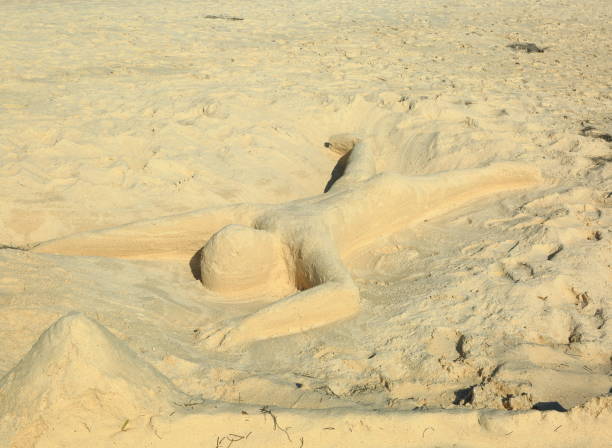 istock Cute sand figure representing a  human laying on the beach  with face down. Aruba island 893021778