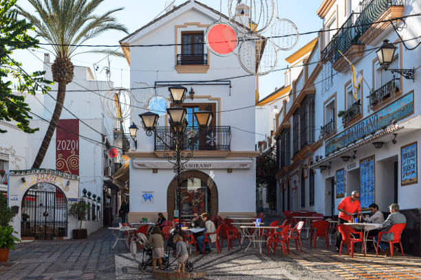 weihnachten-platz mit kleinen café unter den engen gassen der sonnigen stadt marbella, andalusien, spanien - people winter urban scene chair stock-fotos und bilder