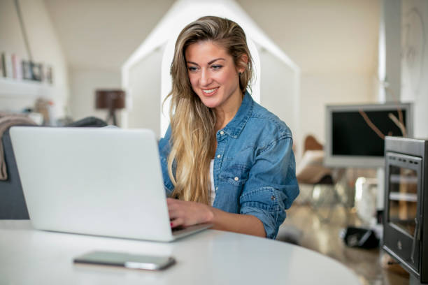 istock Young beautiful woman works for a computer from home with laptop on a white desk 893028472