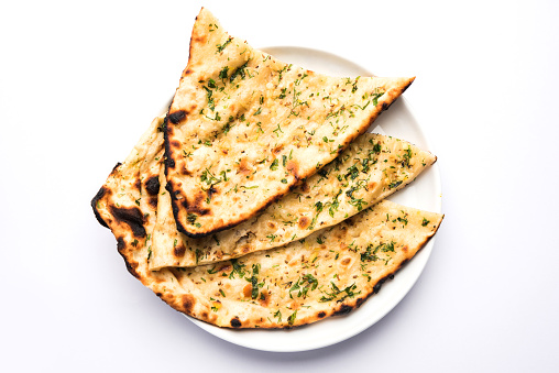 Garlic and coriander naan served in a plate, it's a type of Indian bread or roti flavoured with garlic