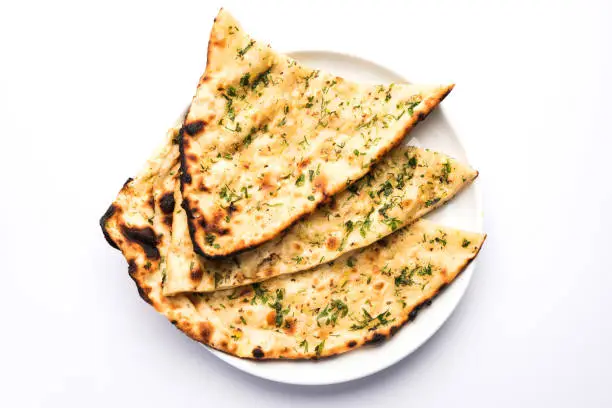 Photo of Garlic and coriander naan served in a plate, it's a type of Indian bread or roti flavoured with garlic