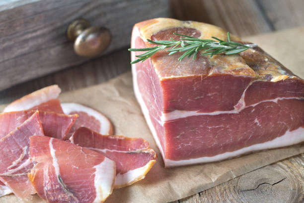 istock Prosciutto with fresh rosemary on the wooden board 893049272