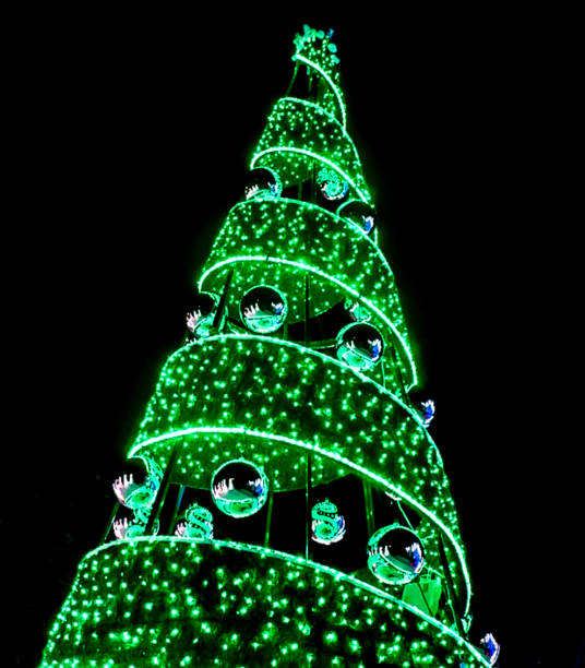 Modern Green Holiday Tree with Ornaments Lit up with Lights