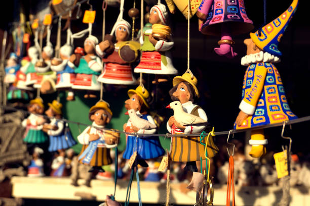 Hand made painted colorful funny ceramic dolls (bells) at sunlight. The souvenir street market. Close view, shallow focus. stock photo