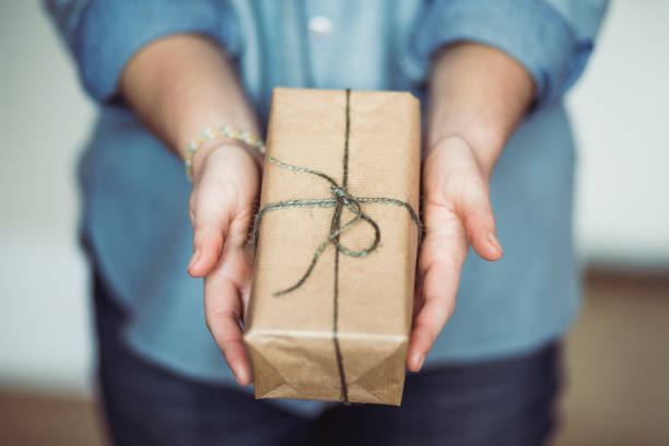 istock Woman sharing a christmas gift 893071506