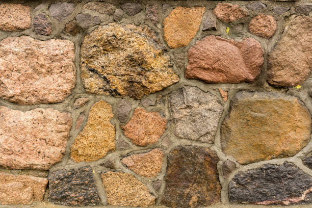 Fragment of boulder retaining wall made of coarse stones. Aged stone wall texture background stock photo
