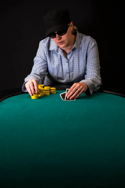istock Woman Poker Player Looking at her Cards 893092700
