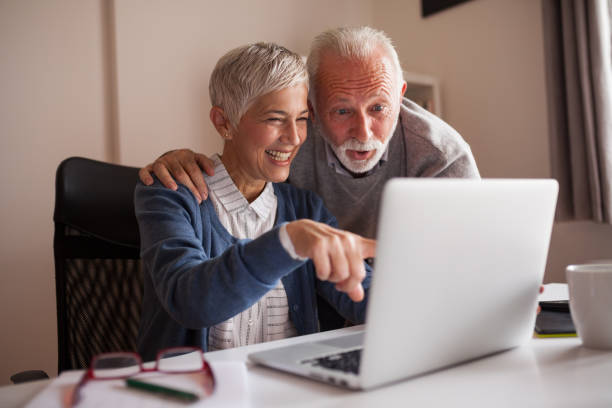 Casal maturo, navegando na internet e comprar. Compras on-line. - foto de acervo