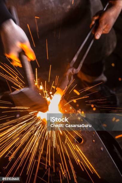 Knife Maker Shaping Hot Piece Of Iron On Anvil With Hammer Stock Photo - Download Image Now
