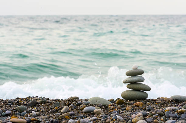 istock Stones pyramid on Black sea beach symbolizing stability, zen, harmony, balance. 893107872