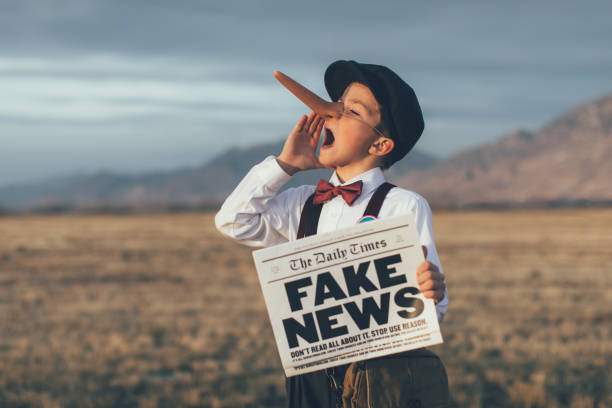 vecchio stile pinocchio news boy holding fake newspaper - dishonesty foto e immagini stock