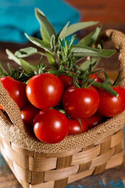 istock Fresh green sage herb, and tasty cherry tomatoes on vine 893115686
