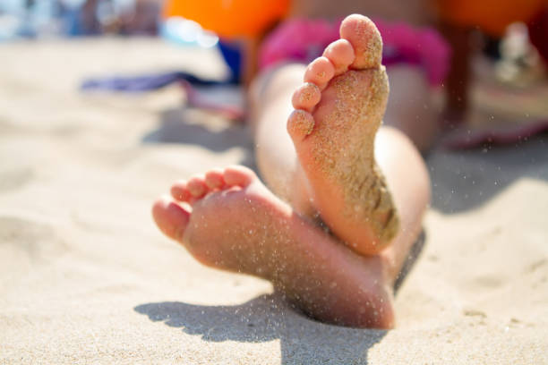 istock Child's feet in the sand 893117826