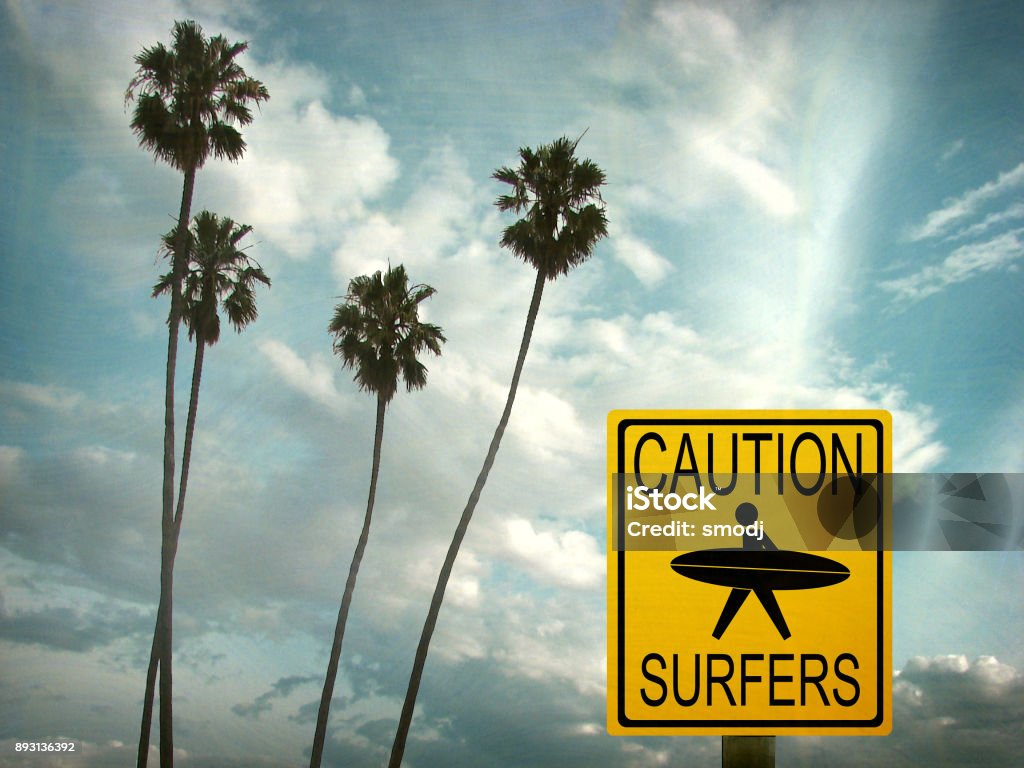 caution surfers sign aged and worn caution surfers sign with palm trees Alertness Stock Photo