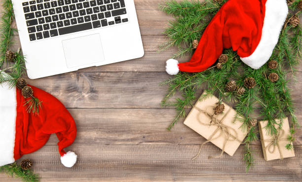 istock Working place laptop Christmas decoration red hat gifts flat lay 893143646