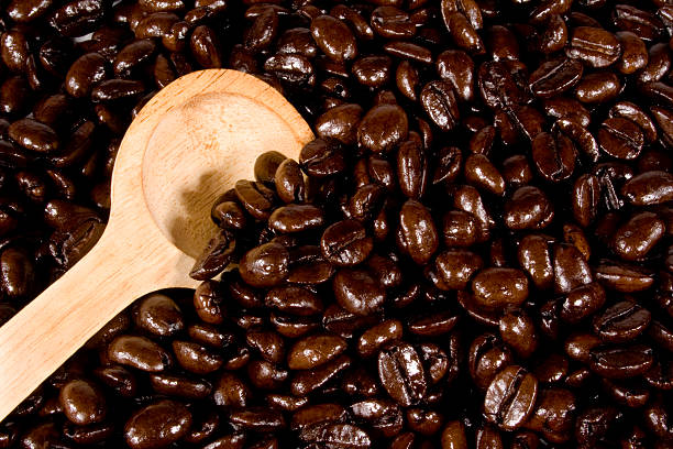 granos de café y cuchara - kona coffee fotografías e imágenes de stock
