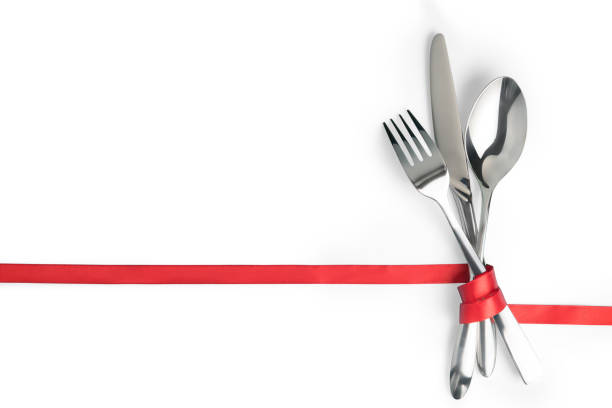 forchetta, cucchiaio e coltello legati con un nastro rosso isolato con spazio di copia - nobody table knife food dinner foto e immagini stock
