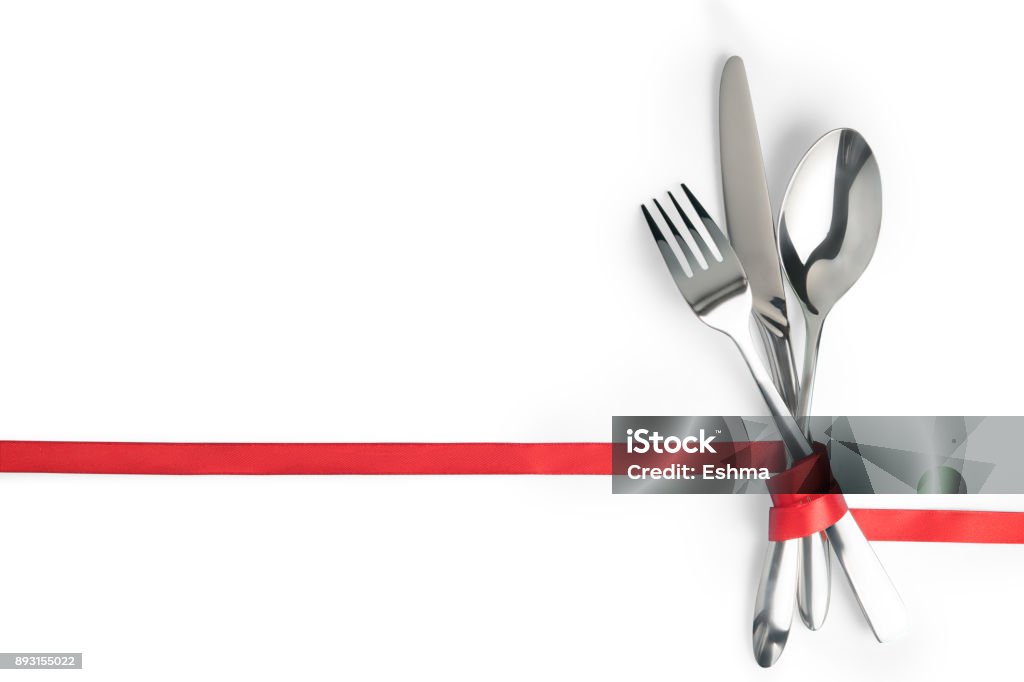 Garfo, colher e faca amarrado com uma fita vermelha isolada com espaço de cópia - Foto de stock de Almoço royalty-free