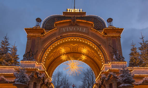 arc d’entrée à la amusment parc tivoli à copenhague, dans la nuit contre le ciel - amusment park photos et images de collection