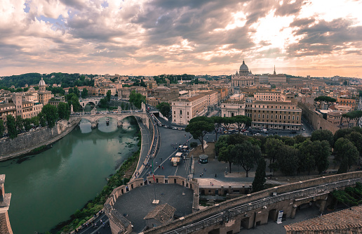 Panoramic aerial wonderful view of Rome with river Tiber and Saint Peter Cathedral at sunset time in Rome, Italy