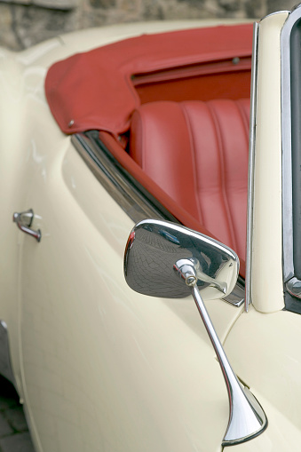 Part of old white convertible from Germany (Mercedes-Benz) with red leather seats.