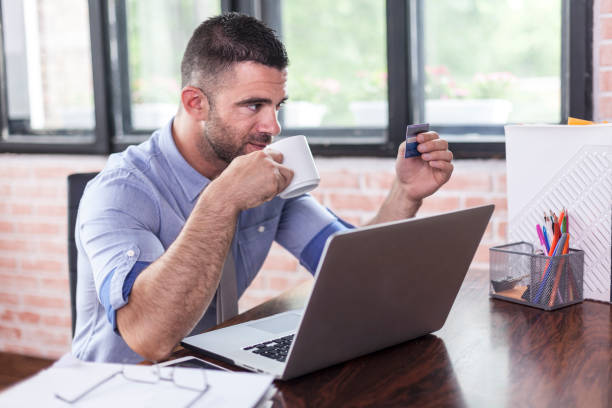 istock Businessman drinking coffee and using credit card 893180828