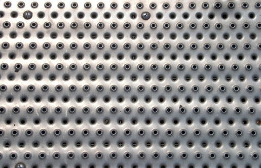 Abstract studded steel sheet metal honeycomb design of a shiny structure background with rugged pattern, directly above view