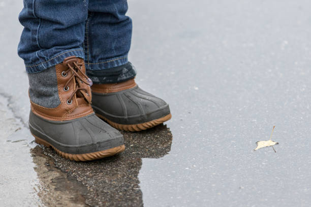 istock Person wearing boots on wet pavement 893186210