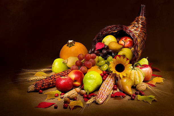 Cornucopia filled with multicolored fruits and vegetables Horn of plenty in warm light cornucopia stock pictures, royalty-free photos & images