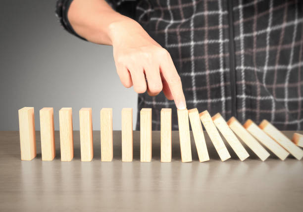 istock Hand Stopping domino concept 893196422