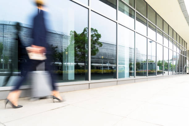 istock Businesswoman pulling wheeled suitcase outside airport 893203202