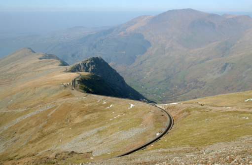 View from near the top of Snowdon, North Wales, showing the mountain railway line and walkers.