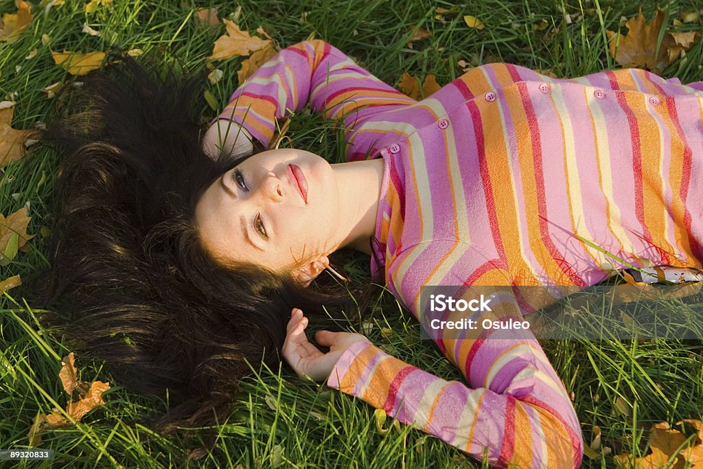 若い美しい女性の芝生で秋の休息 - カエデのロイヤリティフリーストックフォト
