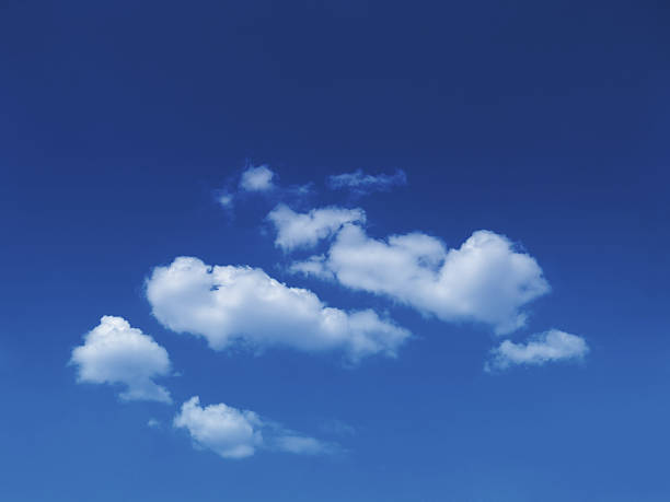 sunny sky background with fluffy white cumulus clouds stock photo