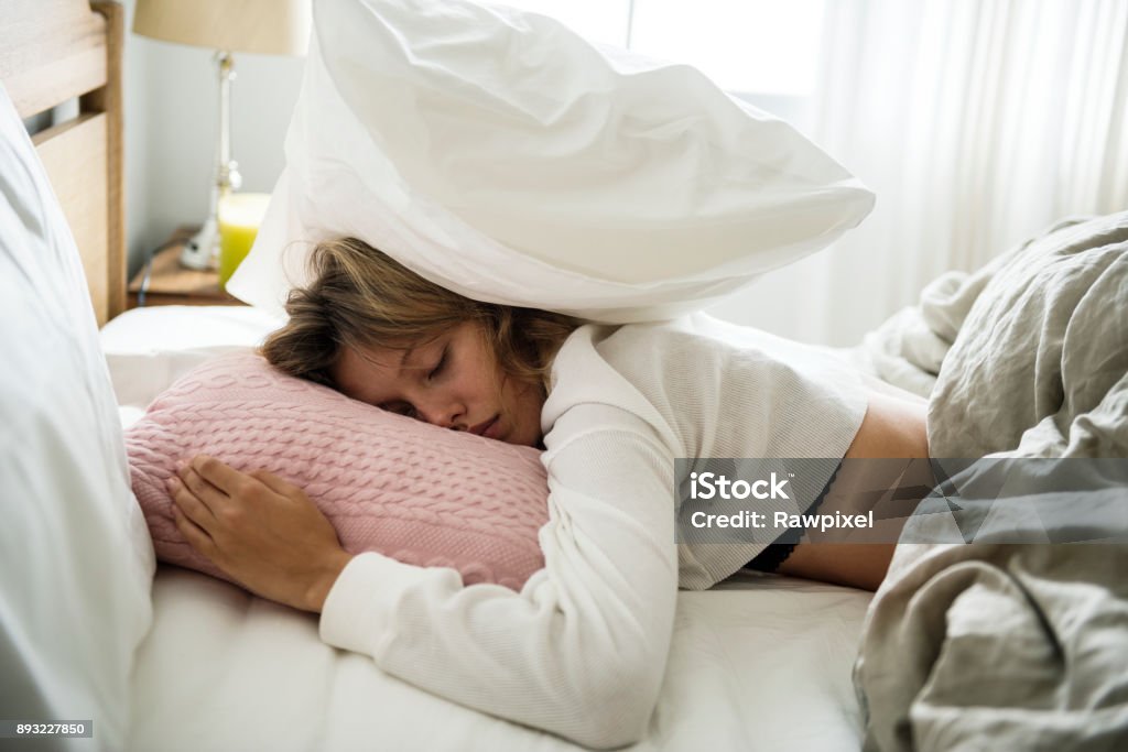 Une femme de race blanche, dormir sur son lit - Photo de Gueule de bois libre de droits