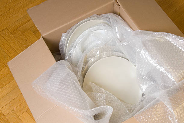 White plates wrapped in bubble wrap stacked in a moving box  /file_thumbview_approve.php?size=1&id=4727250 fragility stock pictures, royalty-free photos & images