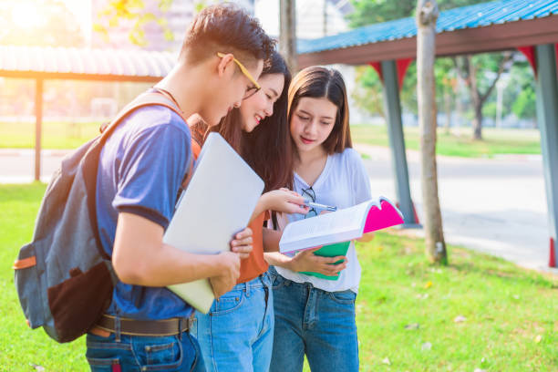 istock Three Asian young campus people tutoring and preparing for final examination in university. Education and learning concept. Friendship and Relation ship concept. College and Outdoors theme. 893244160