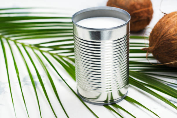 Opened tin can with coconut milk drink Opened tin can with coconut milk drink. Alternative non dairy vegan milk on white stone table coconut milk photos stock pictures, royalty-free photos & images