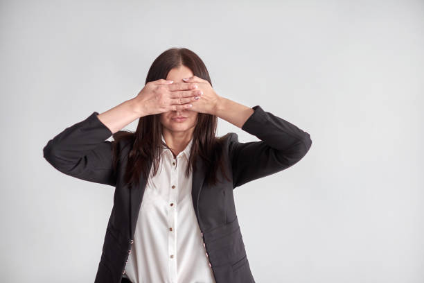 istock woman in a suit, blocking her eyes, business compliance concept 893257032
