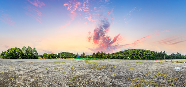 Park sand road large parking lot and green mountain nature landscape at sunset,panoramic view