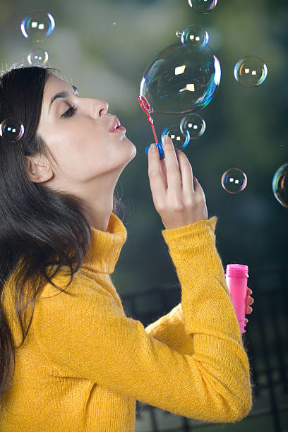 istock Young woman blowing bubbles, outdoors 89326606