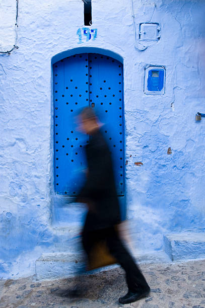 Homem em movimento infront de parede azul e porta - foto de acervo