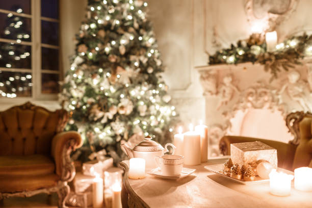 istock Christmas evening by candlelight. classic apartments with a white fireplace, decorated tree, sofa, large windows and chandelier. 893285798