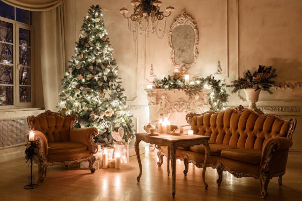 istock Christmas evening by candlelight. classic apartments with a white fireplace, decorated tree, sofa, large windows and chandelier. 893291034